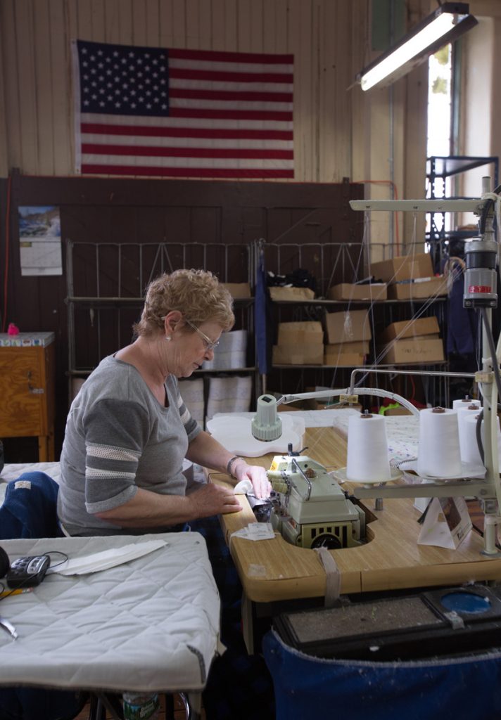 Woman at sewing machine with American Flag