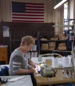 Woman at sewing machine with American Flag